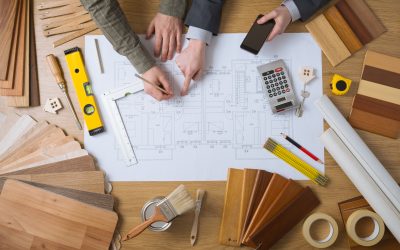 Business people working together on a building project, desktop top view with tools, wood swatches, mobile phone and blueprint